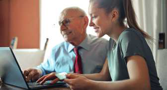 foto di una donna giovane e una persona anziana davanti ad un computer